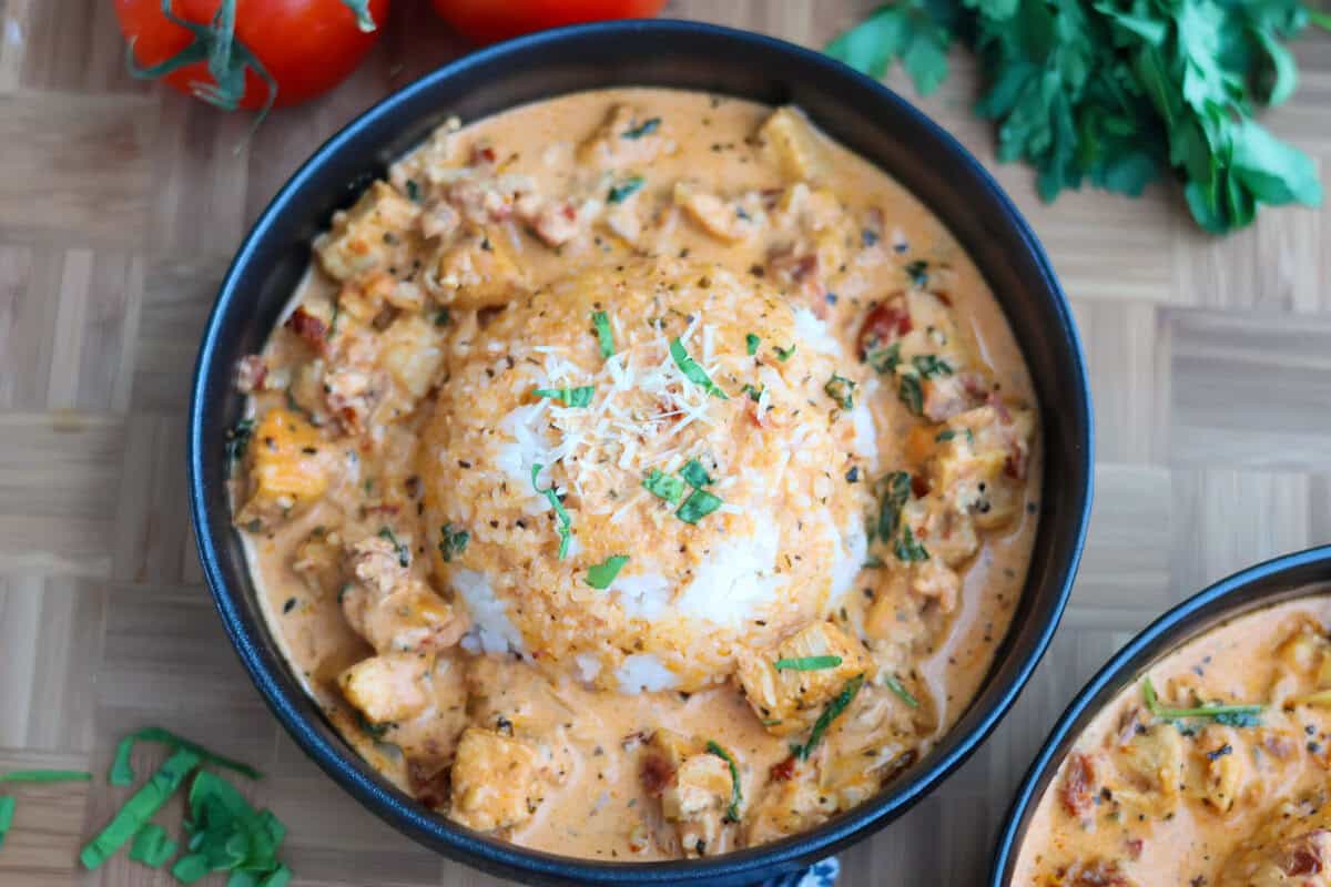 A bowl of rice smothered in Marry Me Chicken and parmesan sauce.