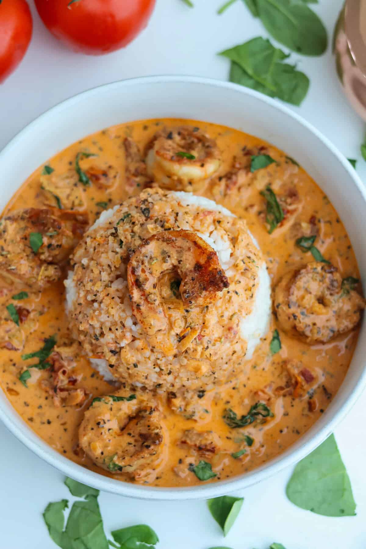 A bowl of marry me shrimp atop a pile of white rice.