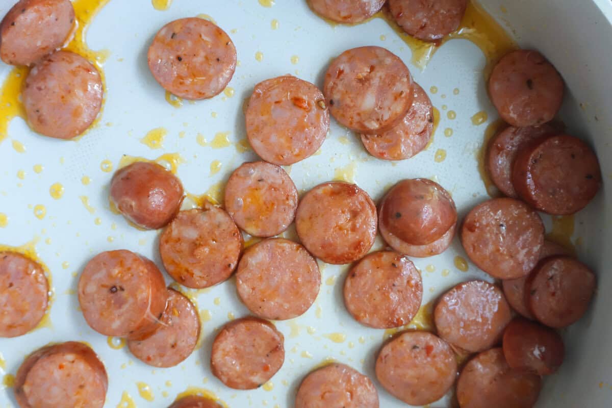 Sausage cooking in a sauté pan.
