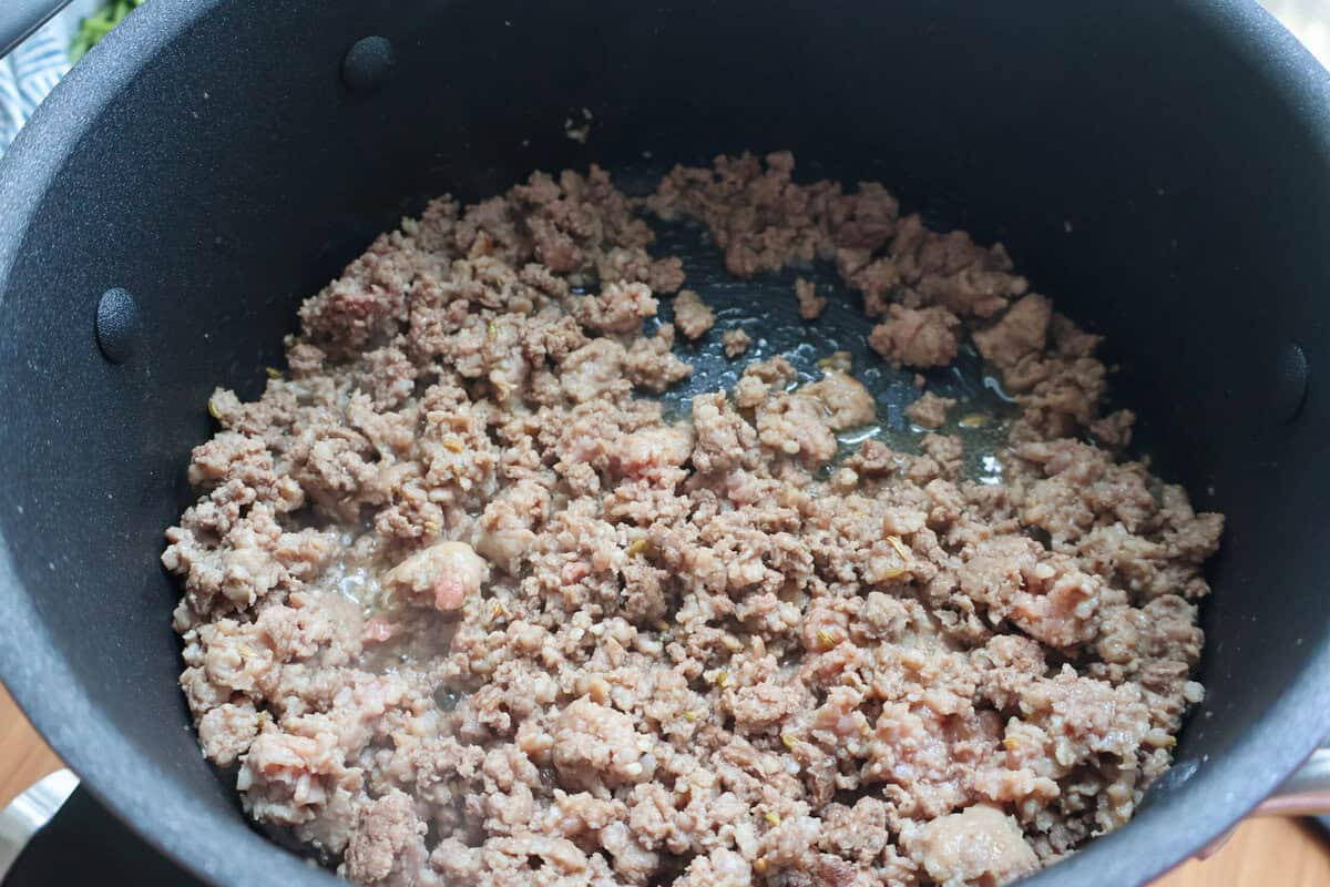 Ground beef and Italian sausage browning in a large pot.