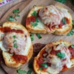 Texas toast meatball melts topped with melted mozzarella on a cutting board