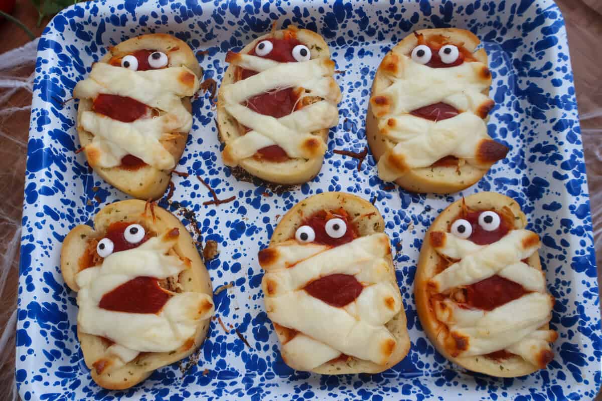 Baked chicken parmesan mummy garlic bread with melted cheese and googly eyes
