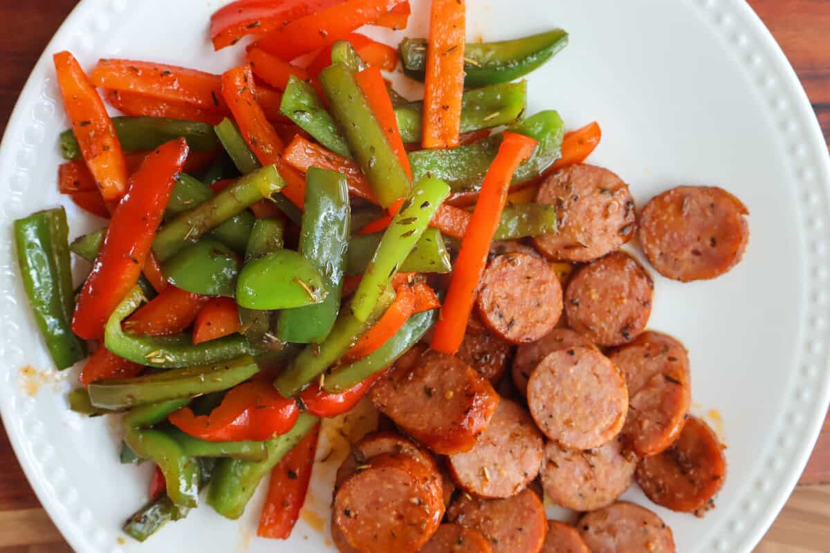 Browned kielbasa and sautéed bell peppers on a plate.
