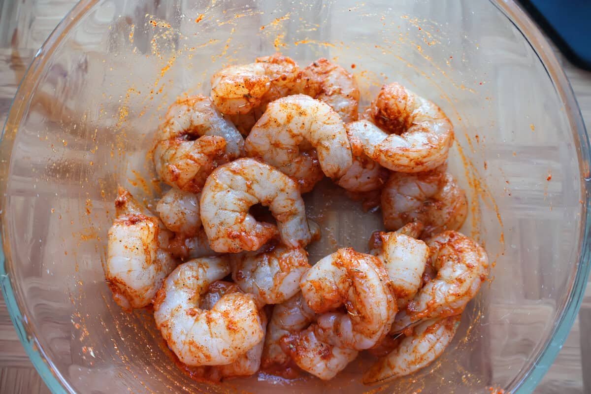 Jumbo shrimp tossed with blackened seasoning in a bowl for surf and turf pasta