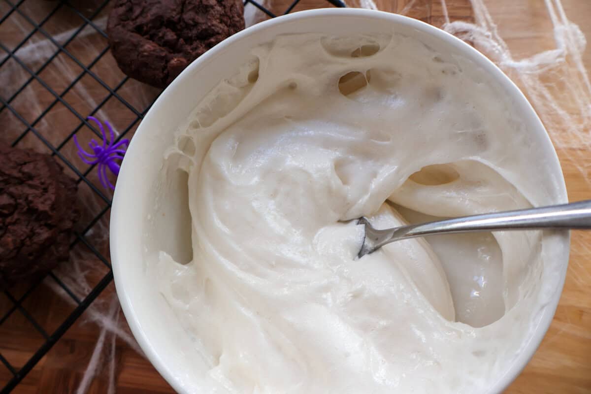 Melted marshmallows in a white bowl for making cookie spider webs